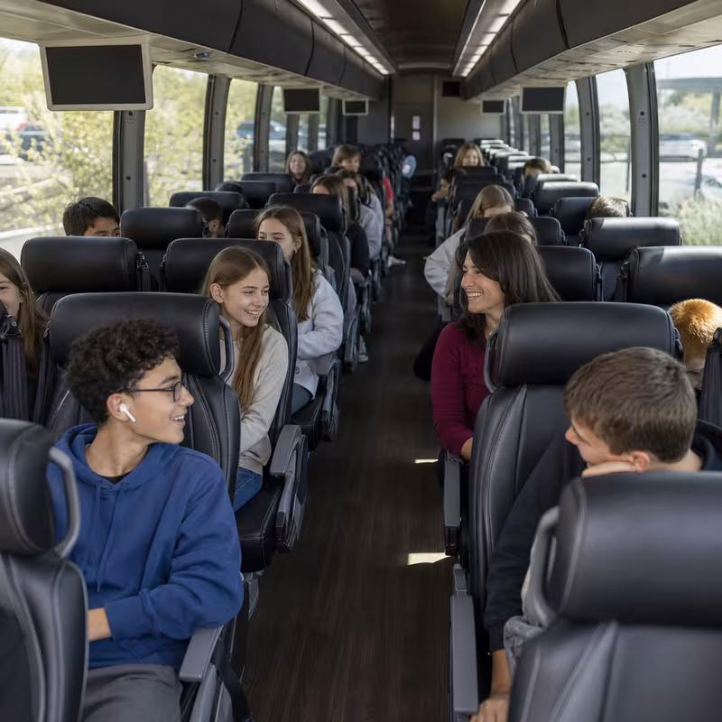 Group boarding a white charter bus for School Transportation transportation in Santa Rosa