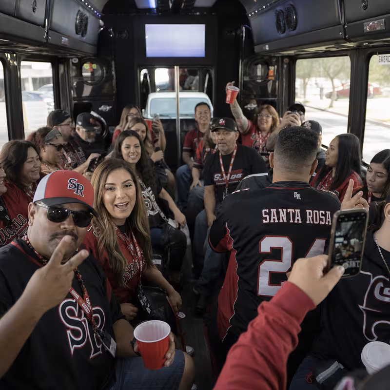 Group boarding a white charter bus for Sporting Event Transportation transportation in Santa Rosa